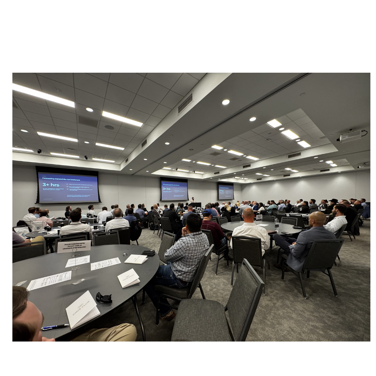 Wide room view of The Gathering with the full audience engaged across multiple tables